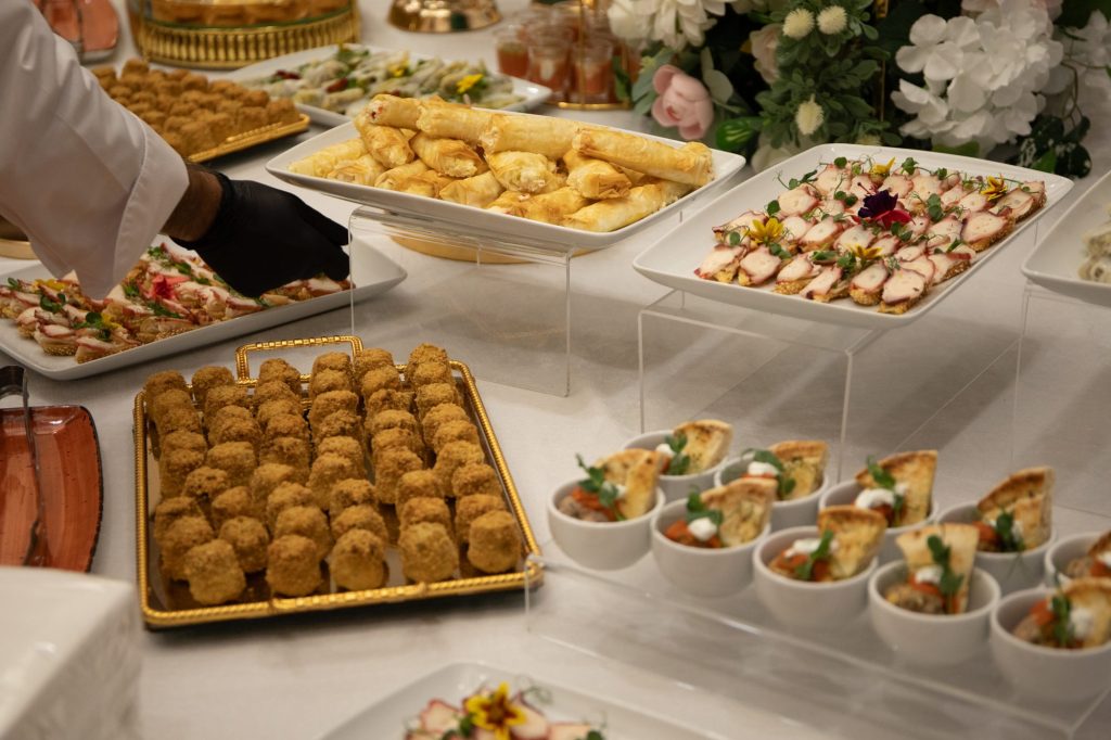 Cernica Events chef wearing gloves arranging finger food at a catering buffet